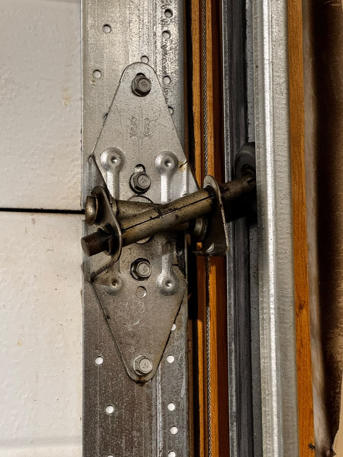 Damaged garage door hinge before replacement